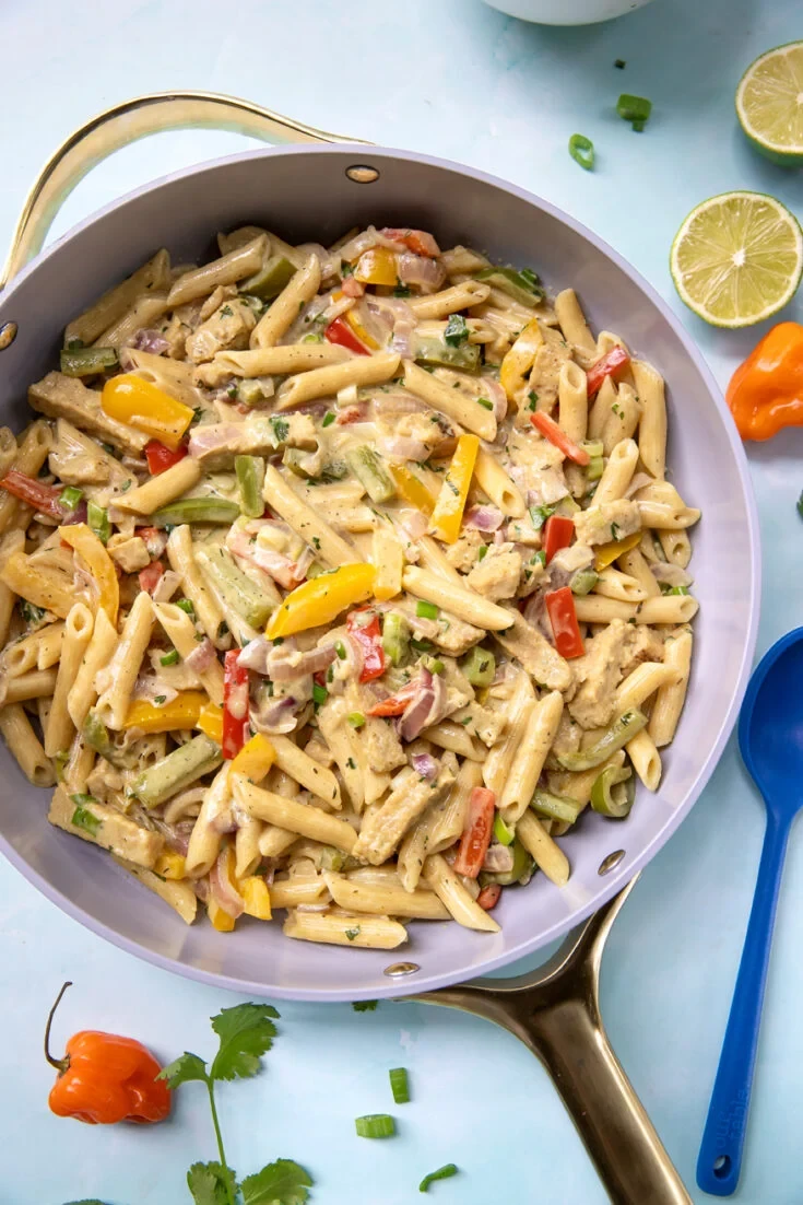 Jerk chicken pasta in skillet with colorful peppers and habanero